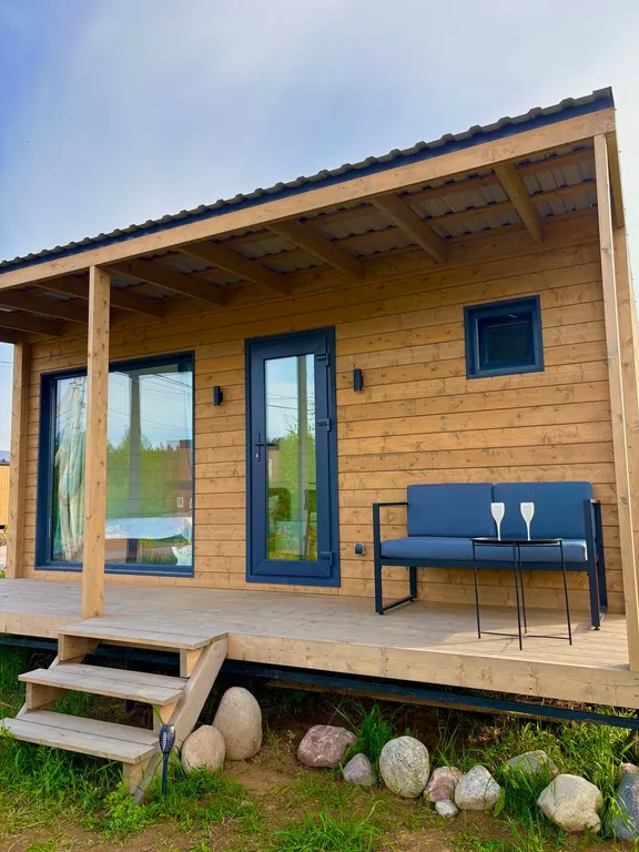 Домик с панорамным окном рядом с озером и видом на лес