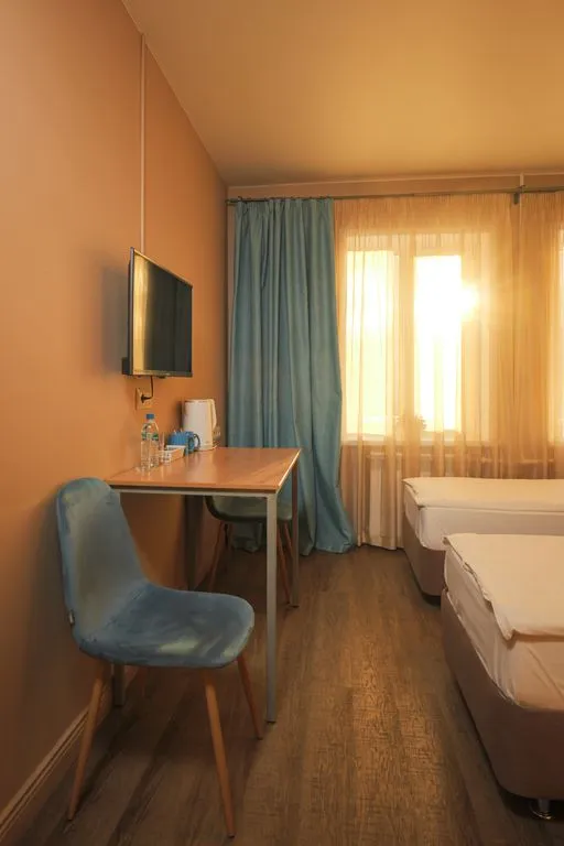 Трёхместный номер светлый с отдельными кроватями и креслом